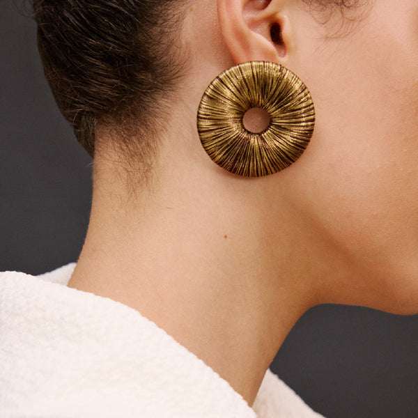 Close-up of a model wearing Boho Gold Earring featuring a refined circular design and metallic threads.