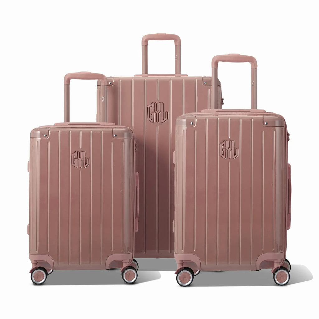 Trois valises rigides GYL Intemporelle rose gold, format cabine et soute, avec poignée trolley déployée.  #couleur_rose gold