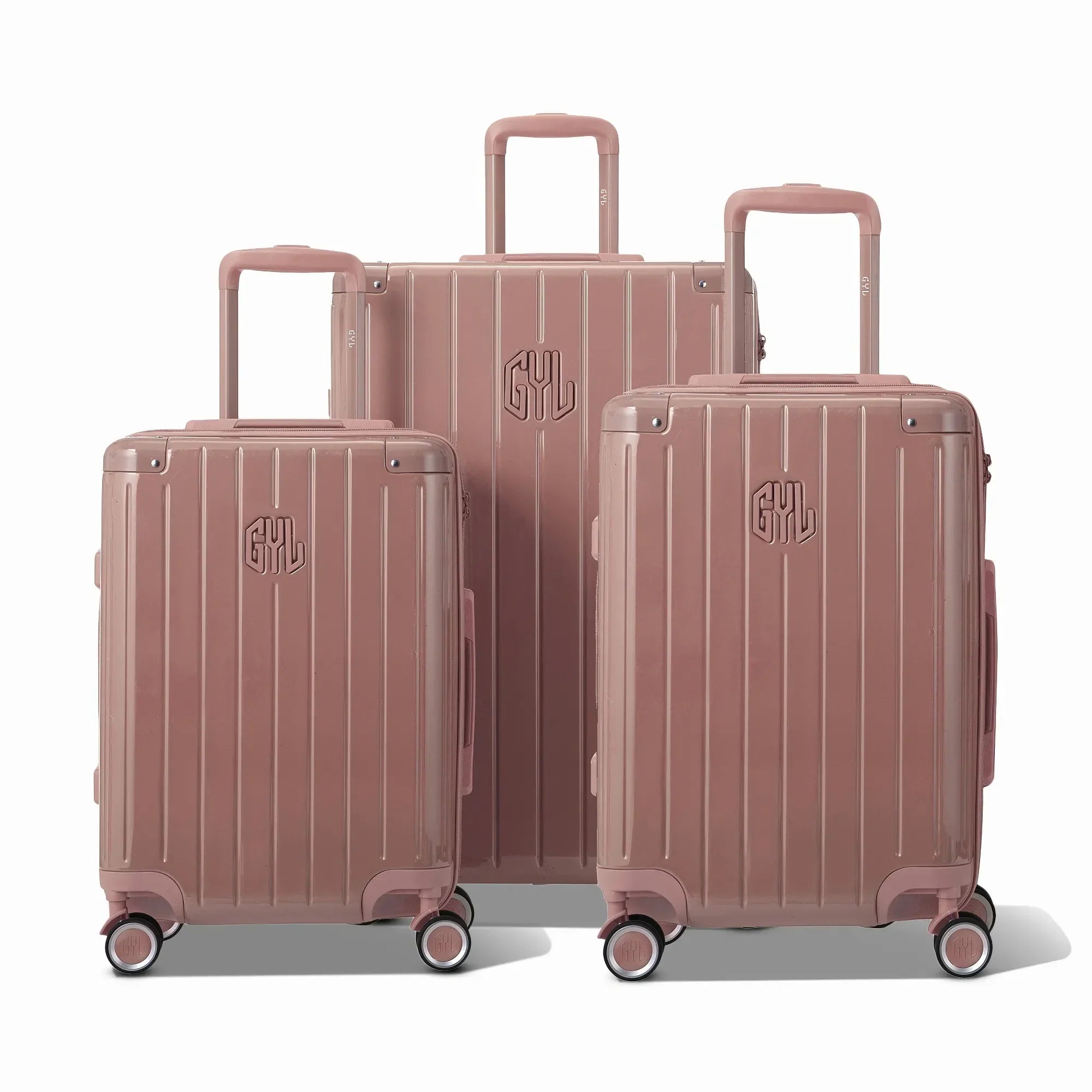 Trois valises rigides GYL Intemporelle rose gold, format cabine et soute, avec poignée trolley déployée.  #couleur_rose gold