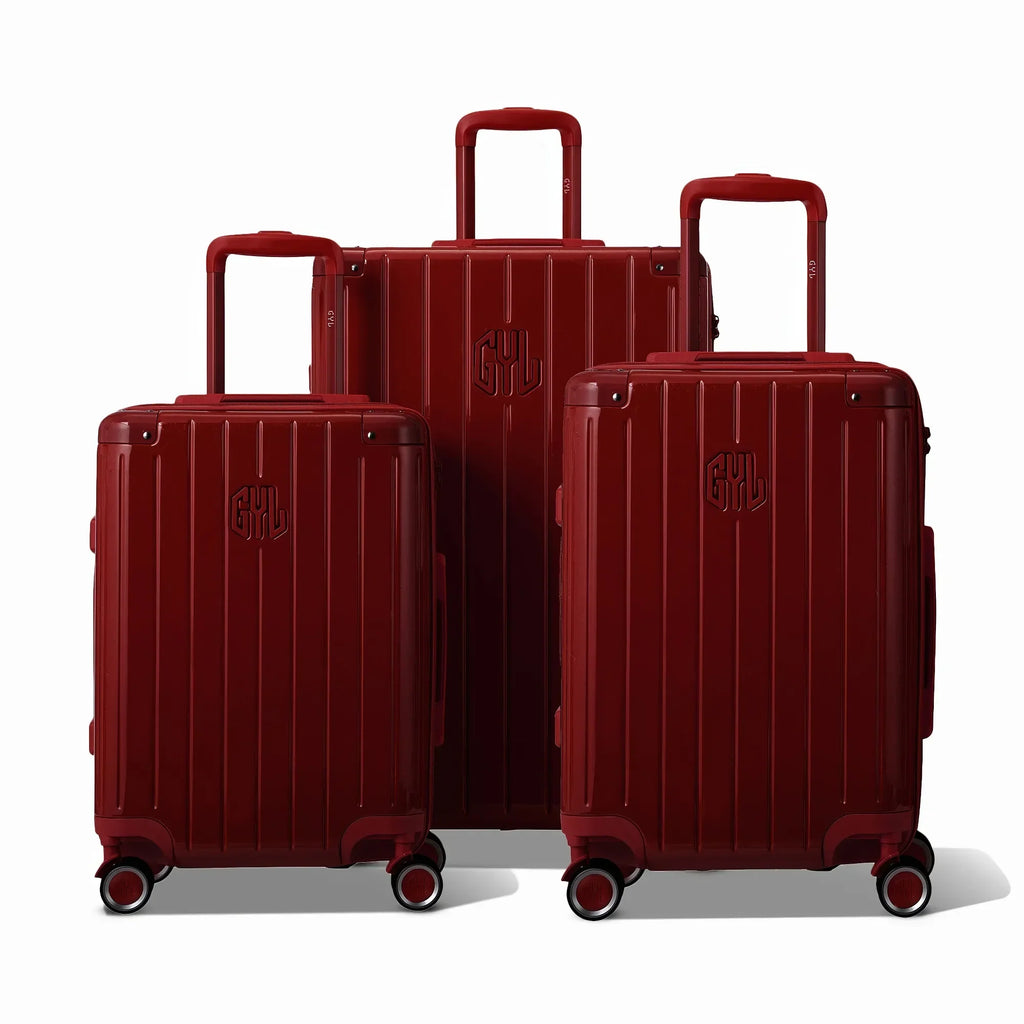 Trois valises rigides GYL Intemporelle rouge foncé, format cabine et soute, avec poignée trolley déployée. #couleur_rouge foncé