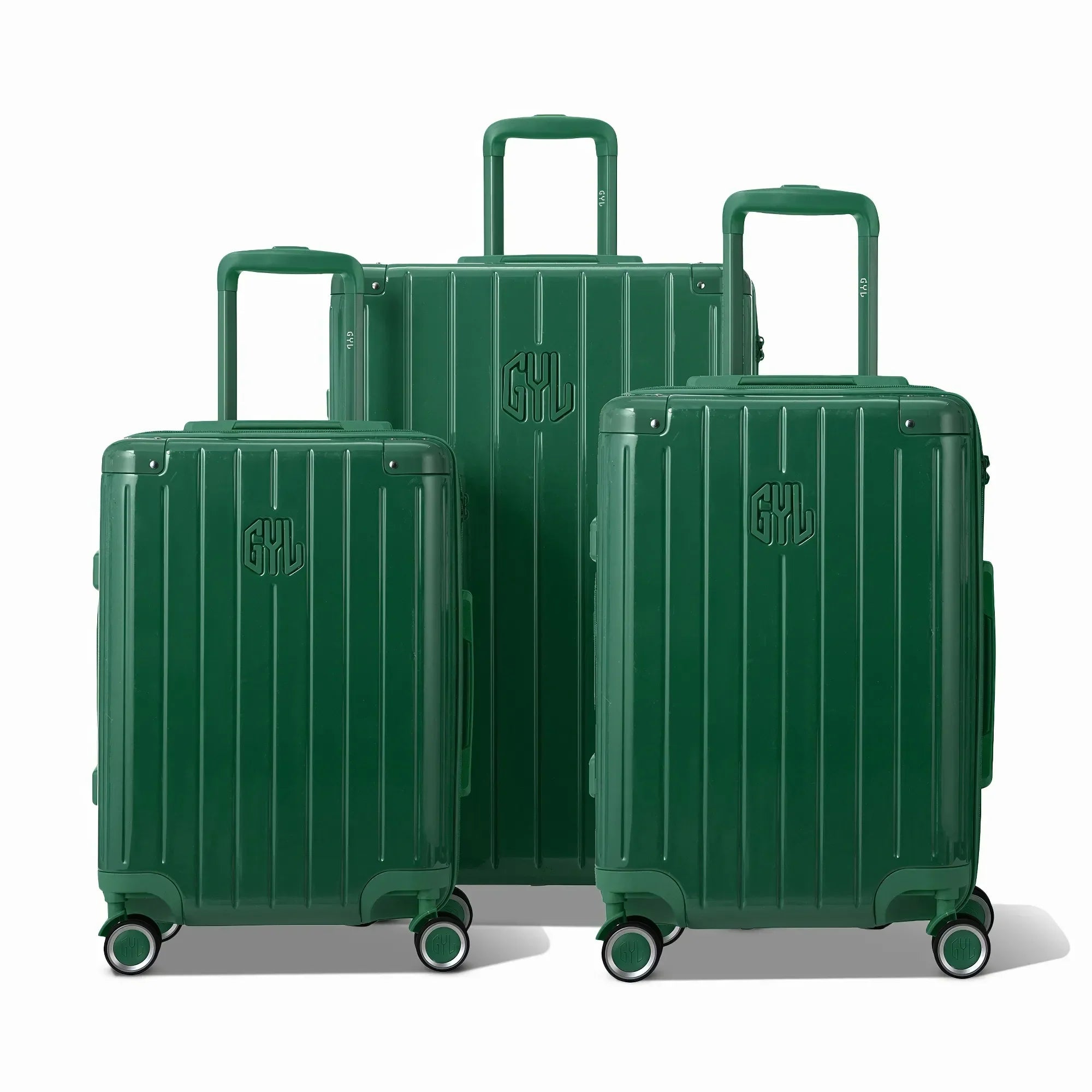Trois valises rigides GYL Intemporelle sapin, format cabine et soute, avec poignée trolley déployée.  #couleur_sapin