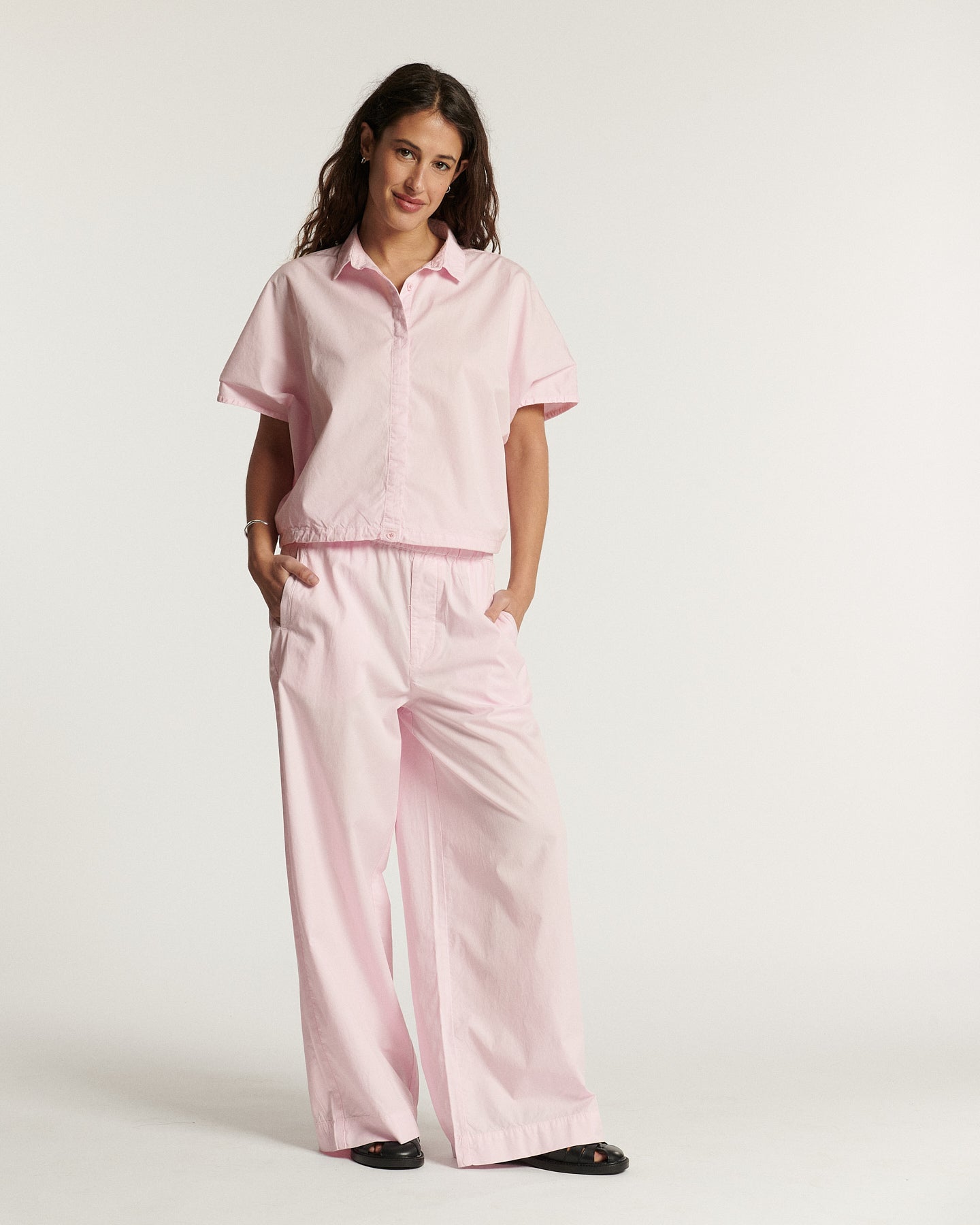 Pantalon en popeline rose clair coupe large et fluide, matière légère en coton adaptée pour l'été, offrant un confort et une silhouette élégante.