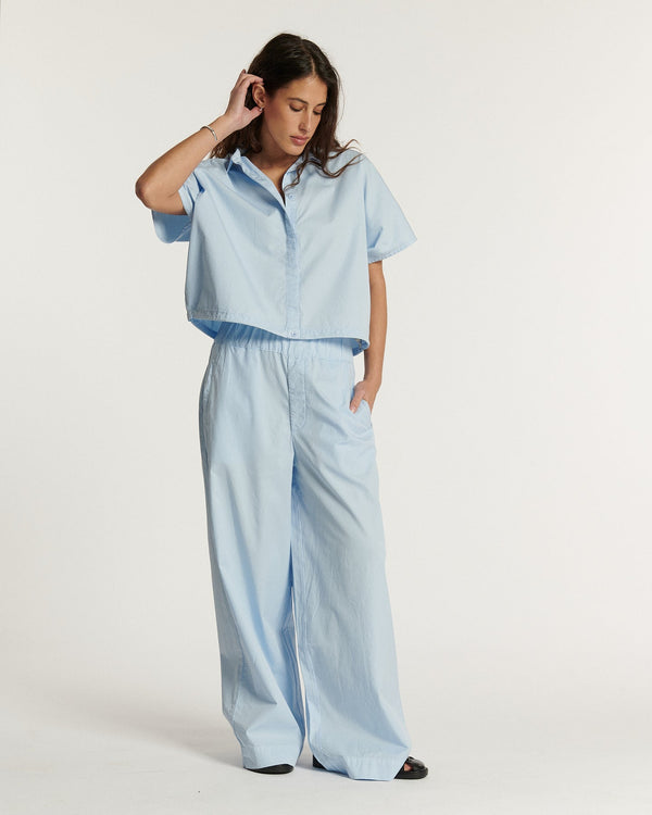 Pantalon large en popeline légère bleu clair, coupe fluide et décontractée adaptée à toutes les morphologies pour un style estival féminin et confortable.