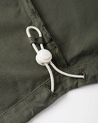 Zoom sur un pantalon en popeline kaki, tissu léger en coton, coupe droite avec cordon de serrage ajustable pour un confort personnalisé.