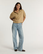 Jean flare en denim bleu clair, coupe ample et confortable, matière douce adaptée à toutes les morphologies féminines pour un style décontracté et estival.