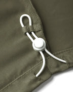 Détail d'un pantalon femme khaki en Tencel avec un cordon de serrage blanc ajustable, tissu fluide et doux au toucher, coupe confortable et adaptée à toutes les morphologies.
