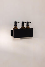 Duschablage SHEA mit drei braunen Flaschen für Duschgel und Shampoo, ideal für ein stilvolles Badezimmerelement.