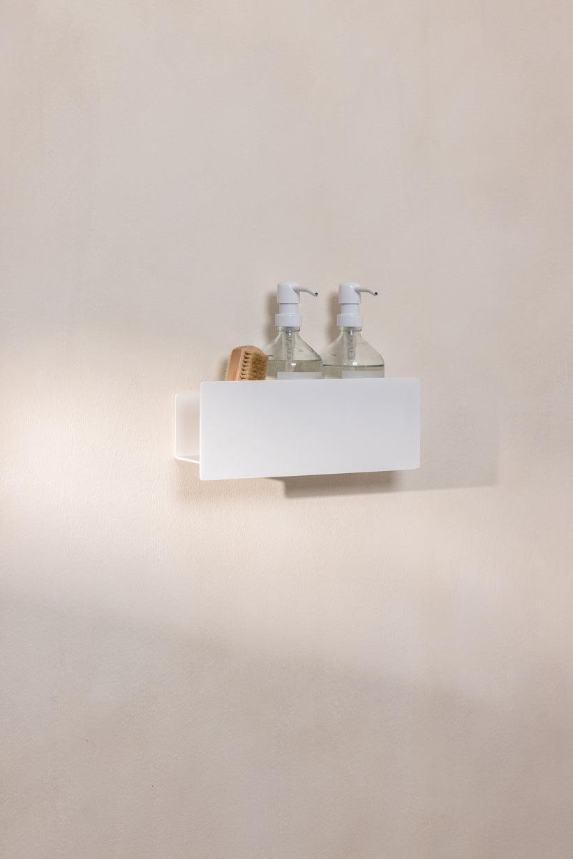 Duschablage SHEA mit zwei Seifenspendern und einer Bürste auf einer Wand im Bad.