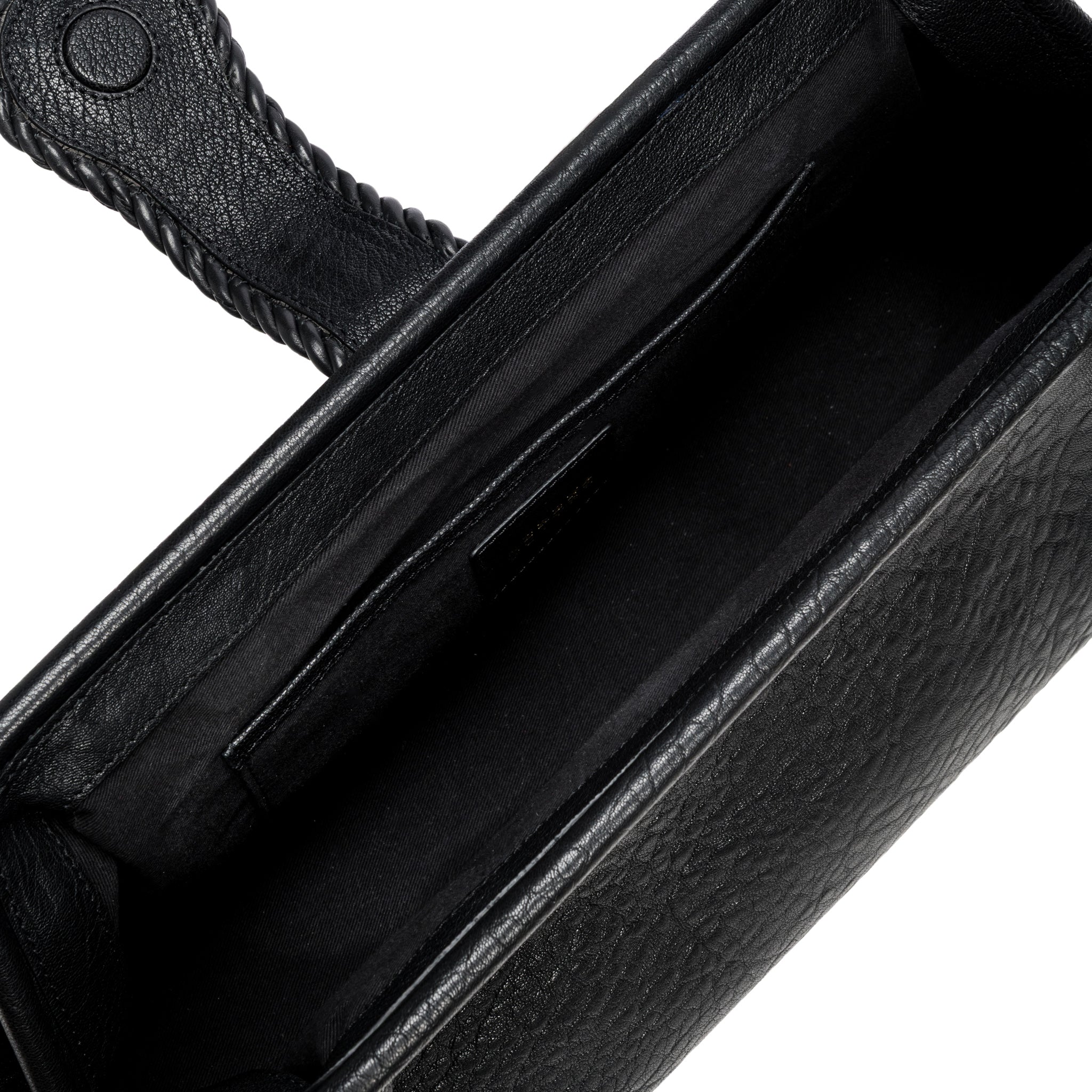 Close-up of a black leather bag with a white interior and card slots