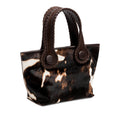 Dark brown and cream cow print pattern small tote bag with dark brown rope handles on a white background.