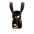 Dark brown and cream cow print pattern small tote bag with open dark brown rope handles on a white background, shown from the side.