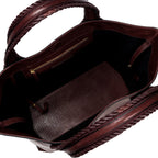 Close-up of a burgundy leather in a shade of dark cherry bag with a same tone interior. It has an inner pocket with zip and keys strap.