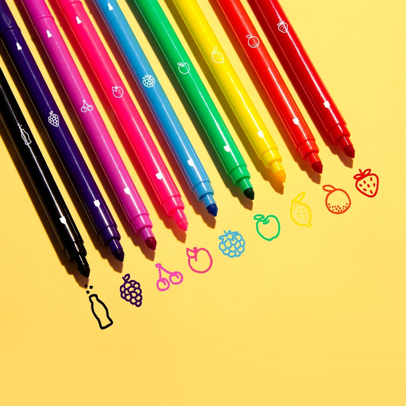 Feutres parfumés OMY alignés avec dessins de fruits : cola, raisin, cerise, pêche, mûre, pomme, citron, orange et fraise – chaque feutre correspond à une senteur fruitée