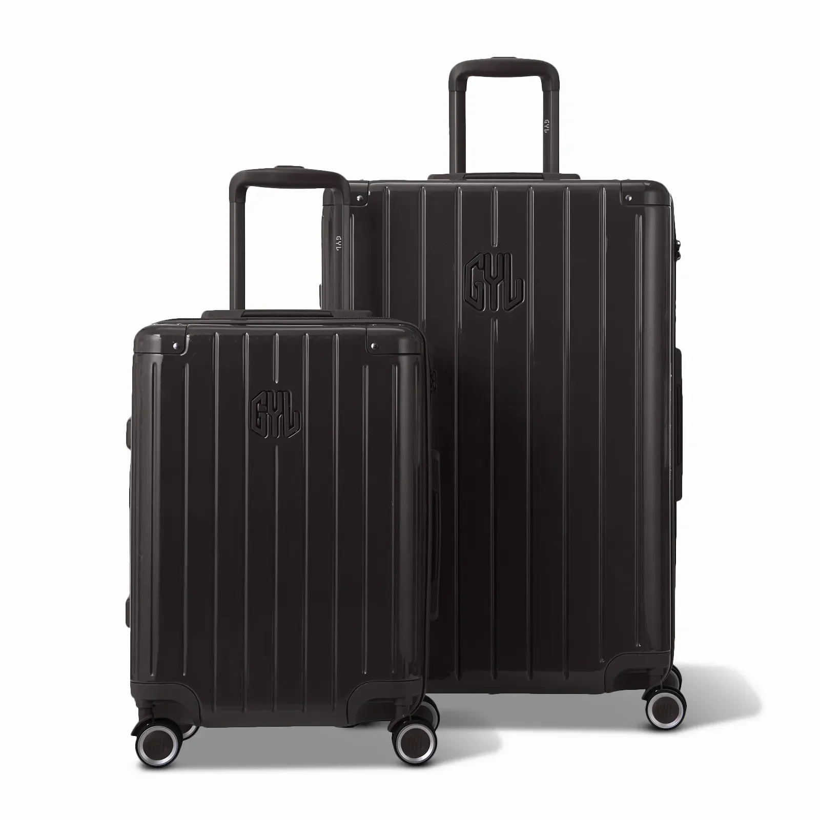 Deux valises rigides GYL Intemporelle noir, 2 formats, avec poignée trolley déployée. #couleur_noir