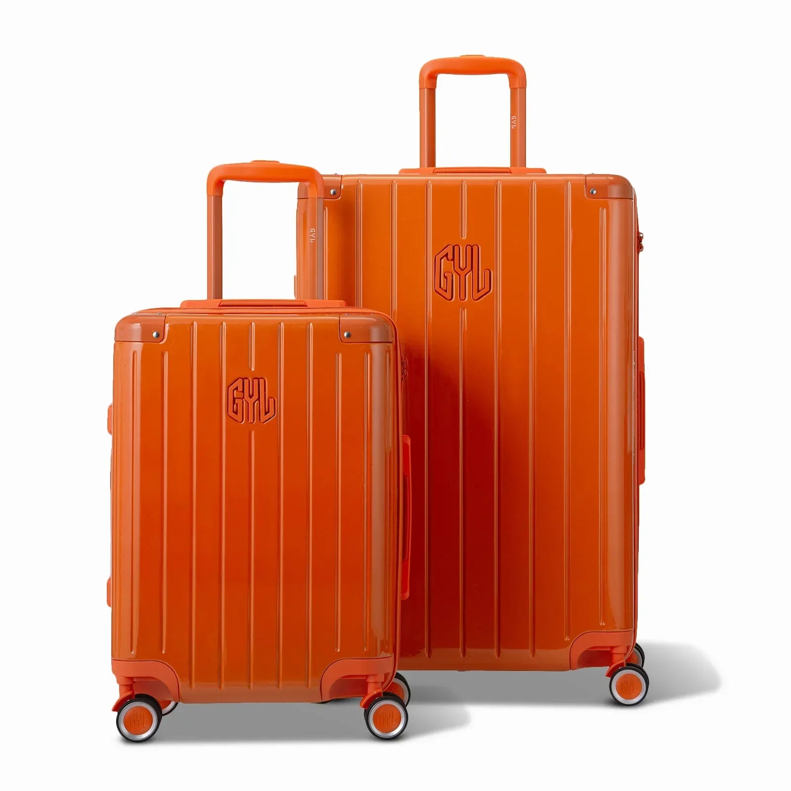 Deux valises rigides GYL Intemporelle orange, 2 formats, avec poignée trolley déployée. #couleur_orange foncé