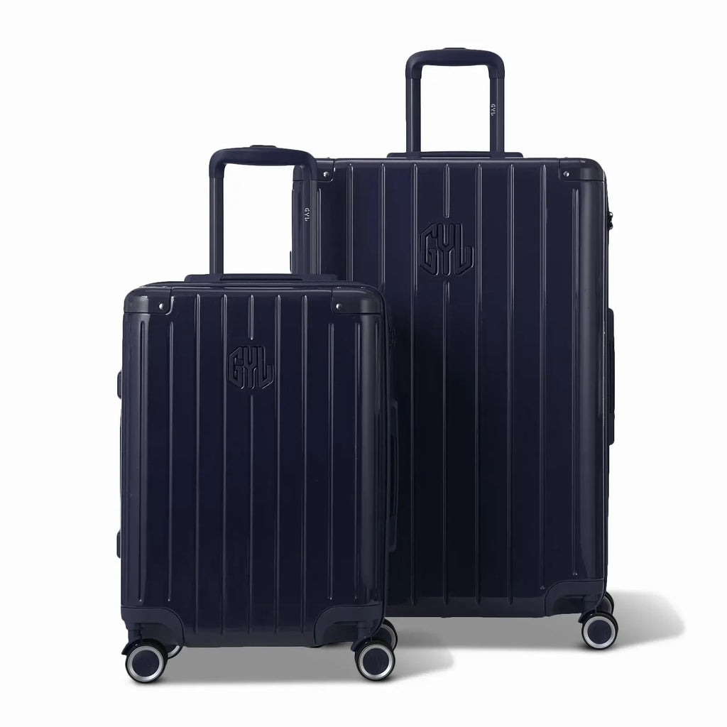 Deux valises rigides GYL Intemporelle marine, format cabine et soute, avec poignée trolley déployée. #couleur_marine
