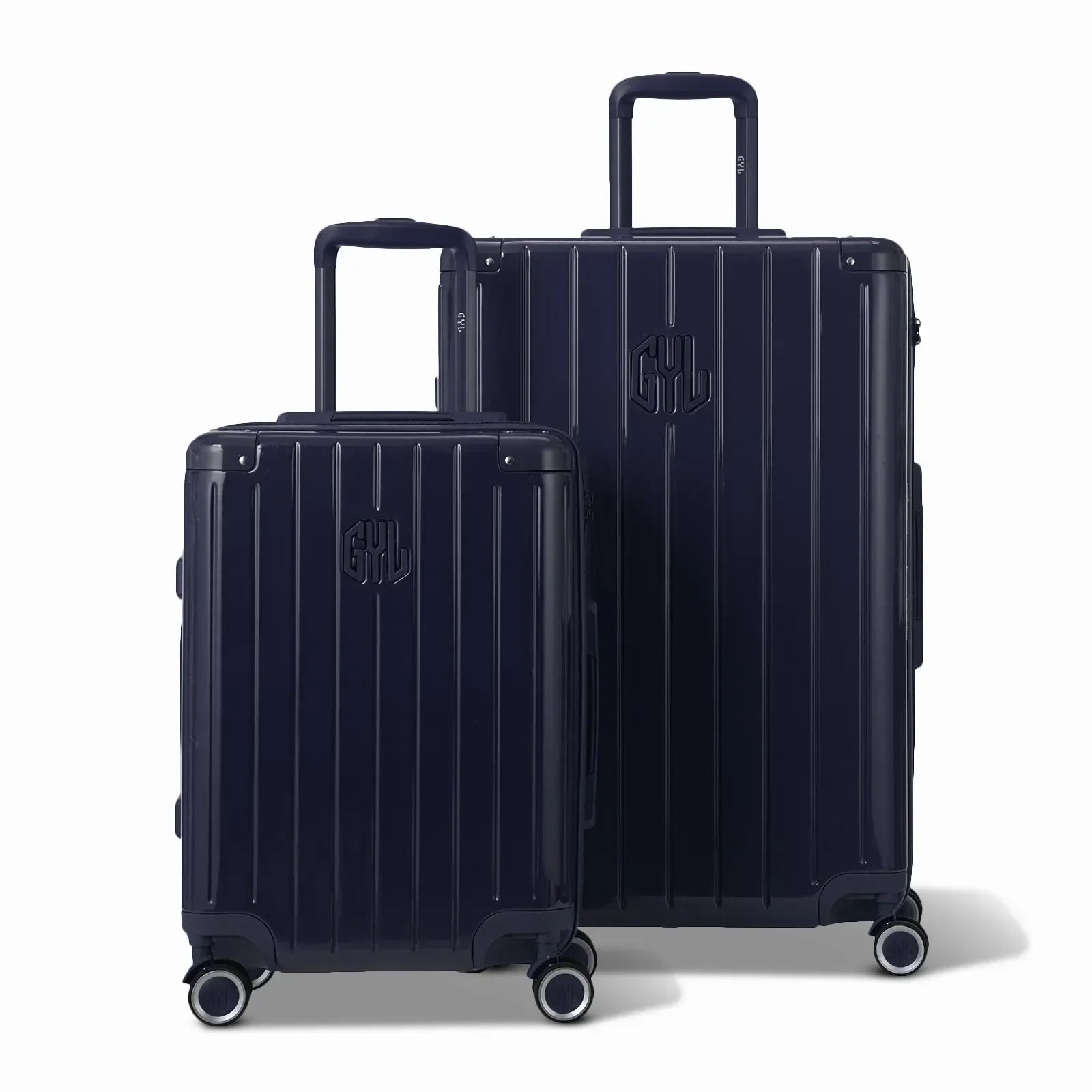 Deux valises rigides GYL Intemporelle marine, format cabine et soute, avec poignée trolley déployée. #couleur_marine