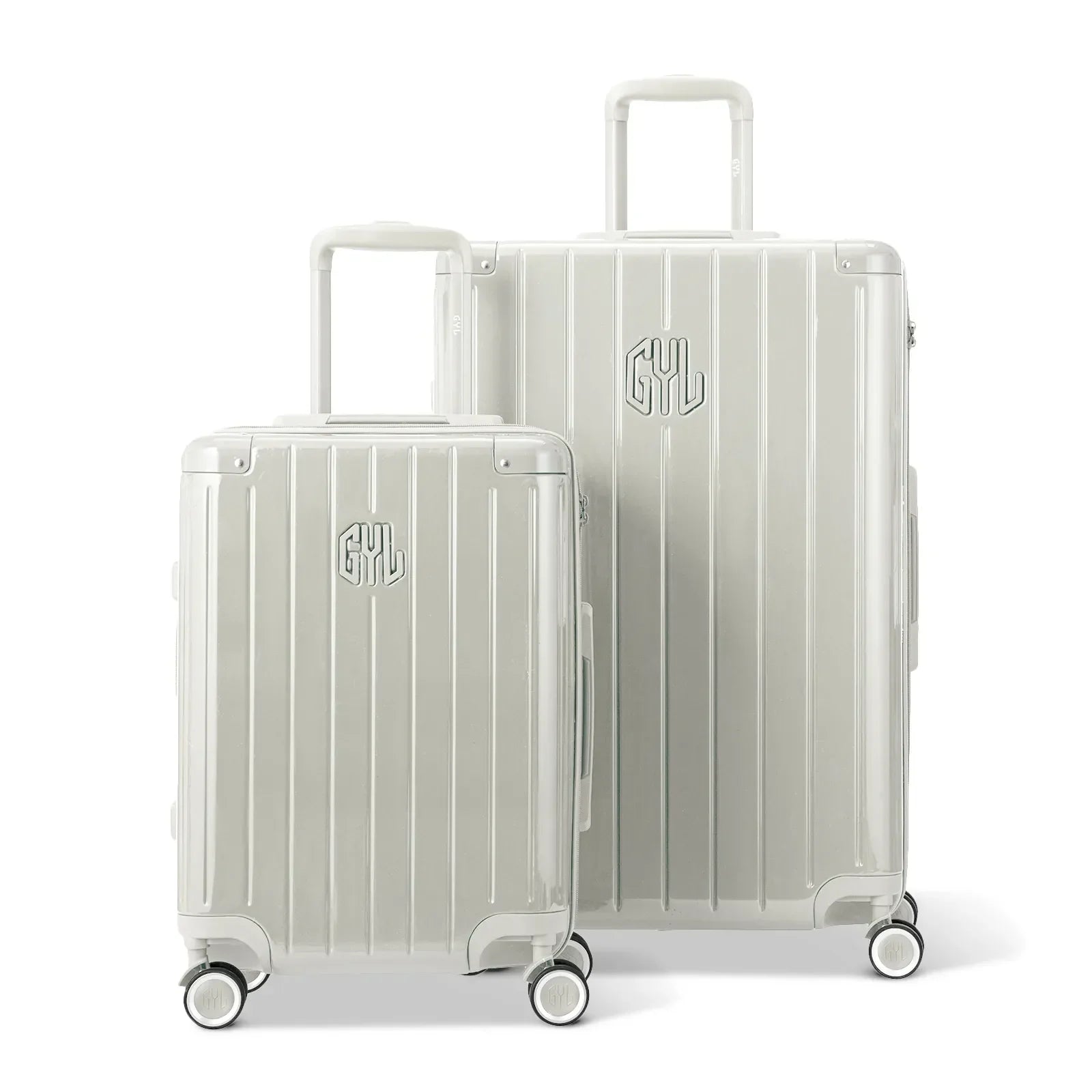 Deux valises rigides GYL Intemporelle sable, format cabine et soute, avec poignée trolley déployée. #couleur_sable
