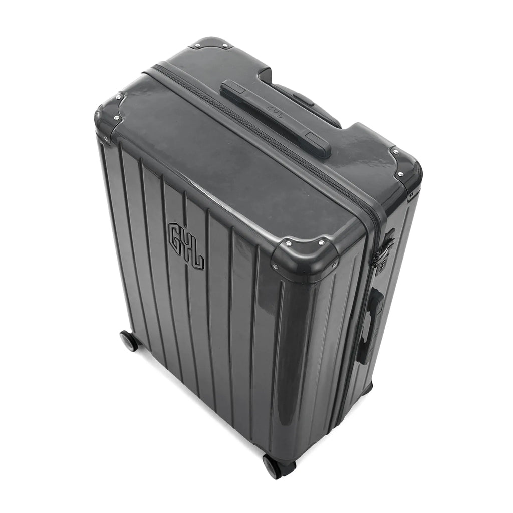 Vue en angle de la valise rigide GYL Intemporelle gris foncé avec coins renforcés et coque nervurée brillante. #couleur_gris foncé