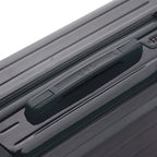 Poignée supérieure rigide de la valise GYL Intemporelle gris foncé avec logo embossé sur le dessus. #couleur_gris foncé