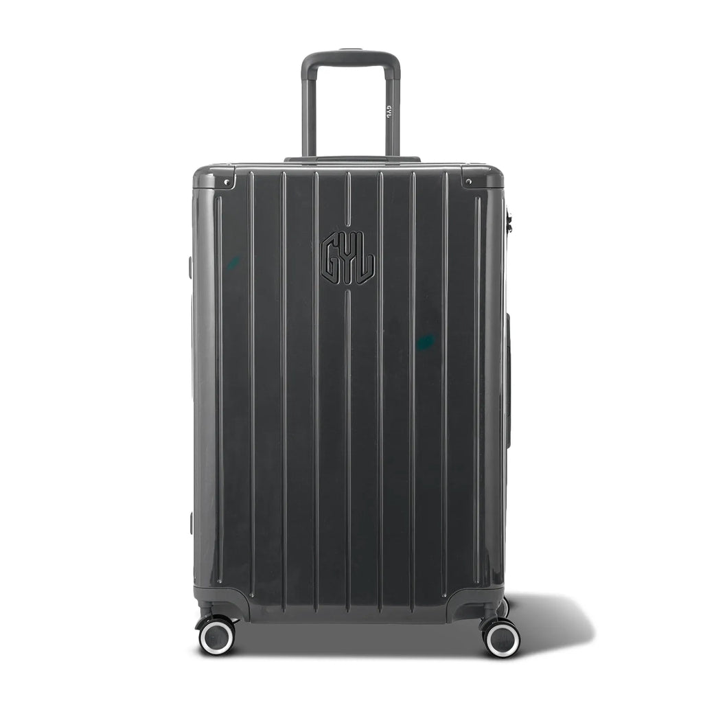Vue avant de la valise rigide GYL Intemporelle gris foncé, logo embossé et roulettes 360 degrés. #couleur_gris foncé