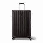 Vue avant de la valise rigide GYL Intemporelle noir, logo embossé et roulettes 360 degrés. #couleur_noir