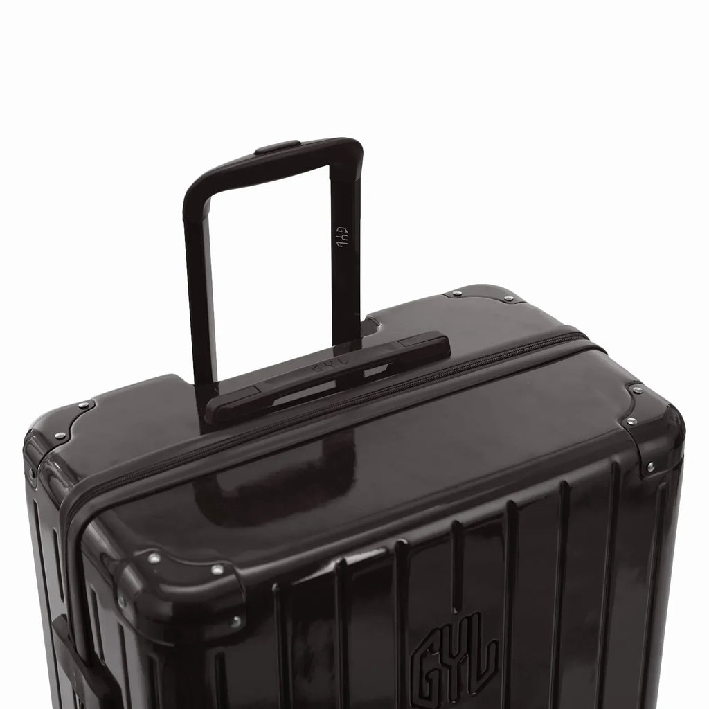 Poignée trolley télescopique GYL déployée sur la valise Intemporelle noir en polycarbonate. #couleur_noir