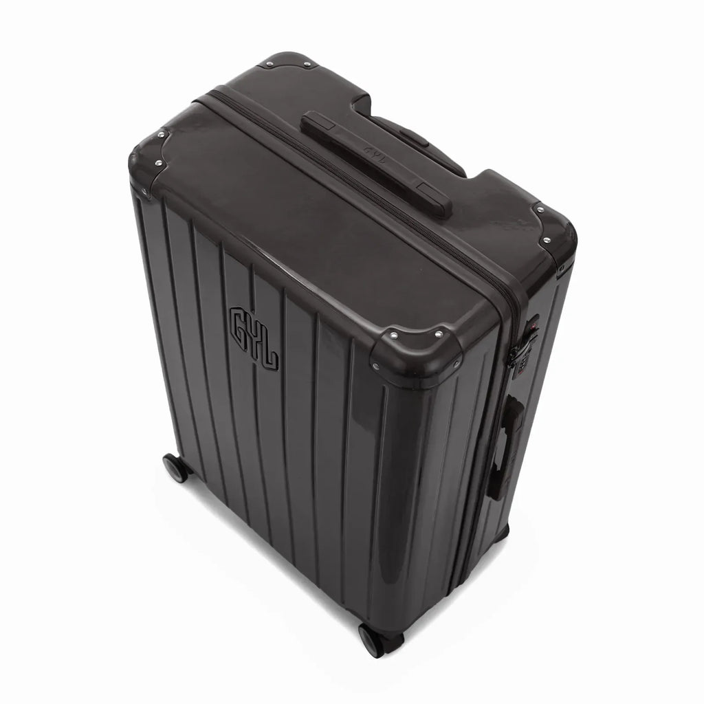 Vue en angle de la valise rigide GYL Intemporelle noir avec coins renforcés et coque nervurée brillante. #couleur_noir