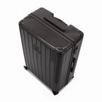 Vue en angle de la valise rigide GYL Intemporelle noir avec coins renforcés et coque nervurée brillante. #couleur_noir