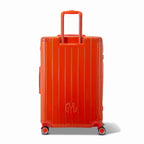 Vue arrière de la valise rigide GYL Intemporelle orange avec poignées intégrées et roulettes pivotantes. #couleur_orange foncé