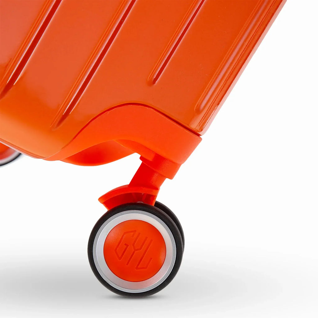 Roue double 360° de la valise GYL Intemporelle orange avec gravure du logo GYL sur le moyeu. #couleur_orange foncé