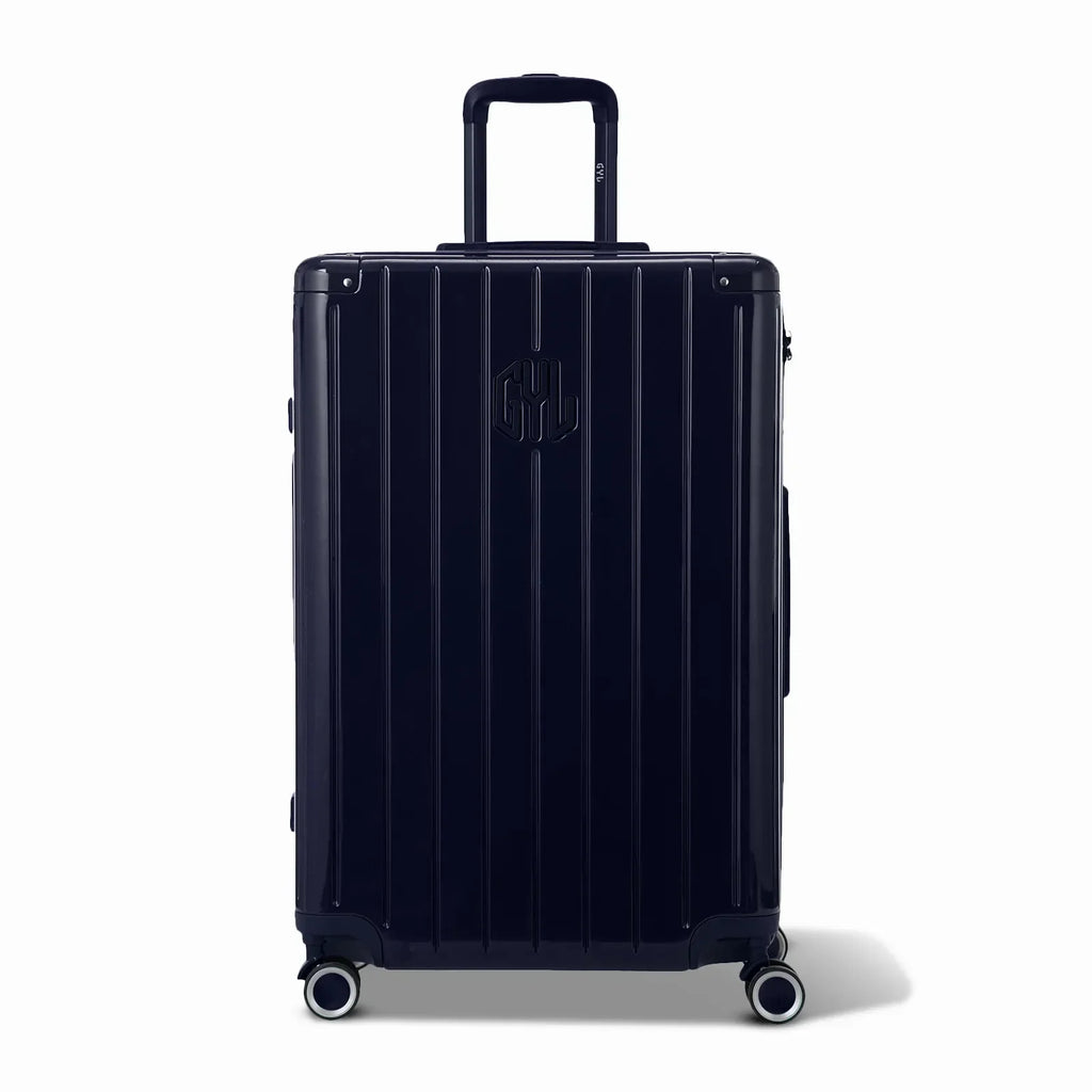 Vue avant de la valise rigide GYL Intemporelle marine, logo embossé et roulettes 360 degrés. #couleur_marine