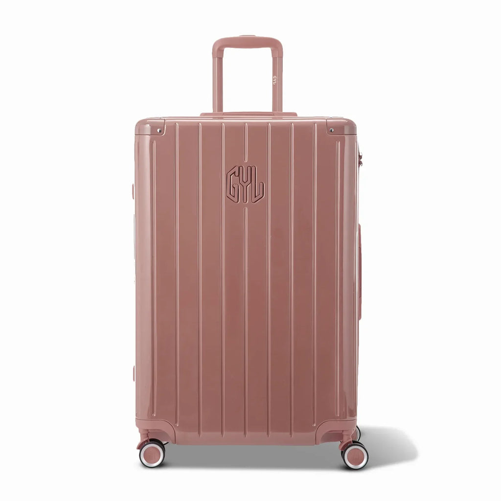 Vue avant de la valise rigide GYL Intemporelle rose gold, logo embossé et roulettes 360 degrés. #couleur_rose gold