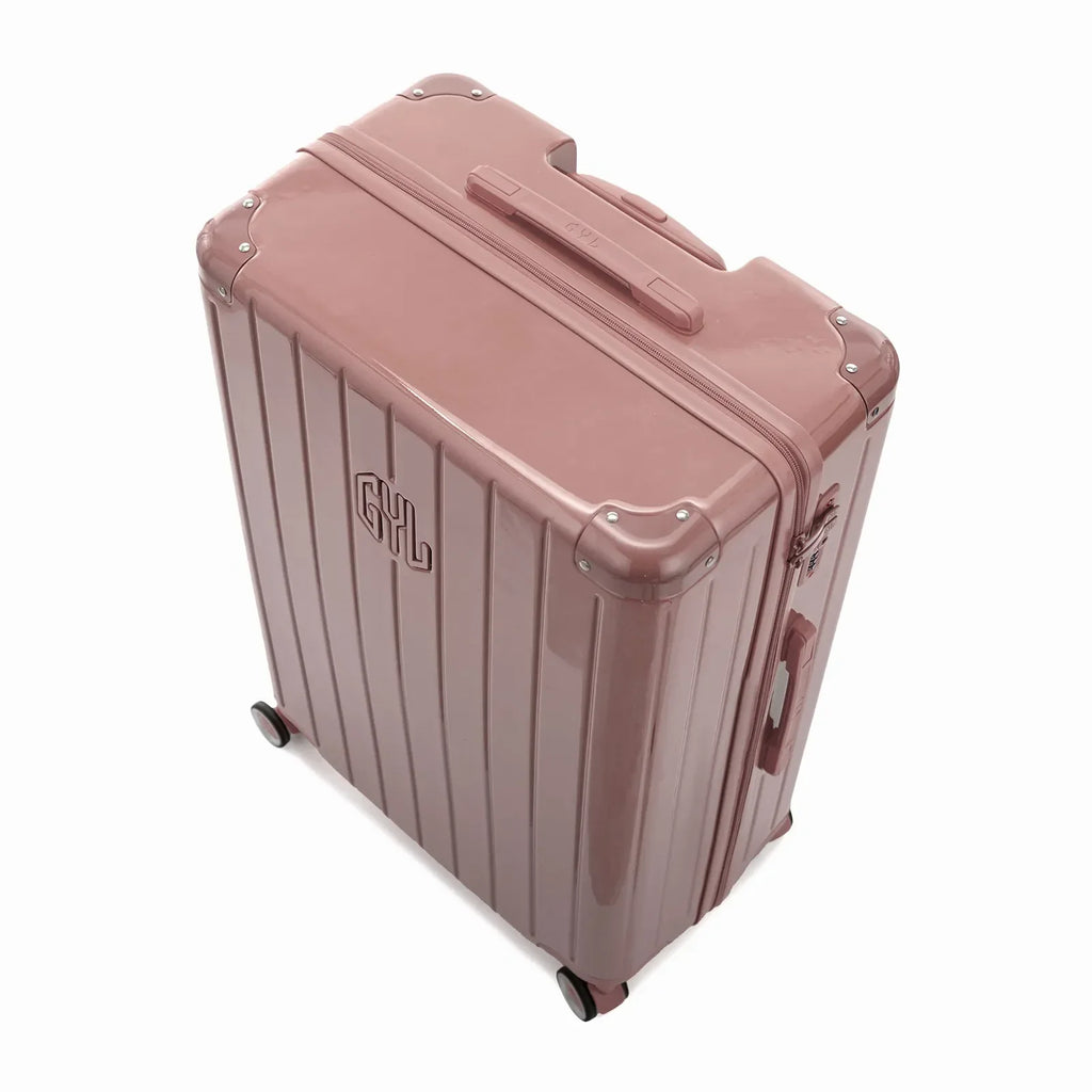 Vue en angle de la valise rigide GYL Intemporelle rose gold avec coins renforcés et coque nervurée brillante. #couleur_rose gold