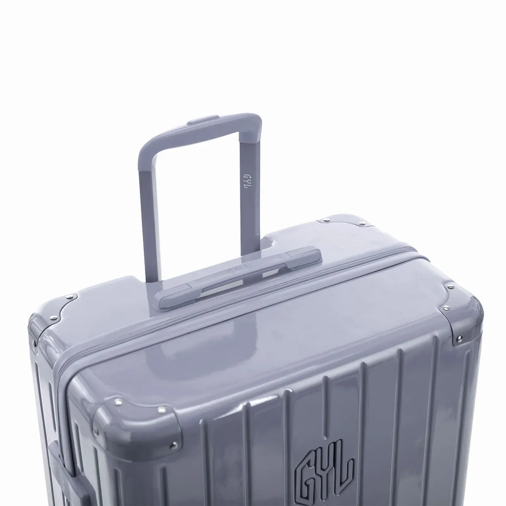 Poignée trolley télescopique GYL déployée sur la valise Intemporelle argent en polycarbonate. #couleur_argent