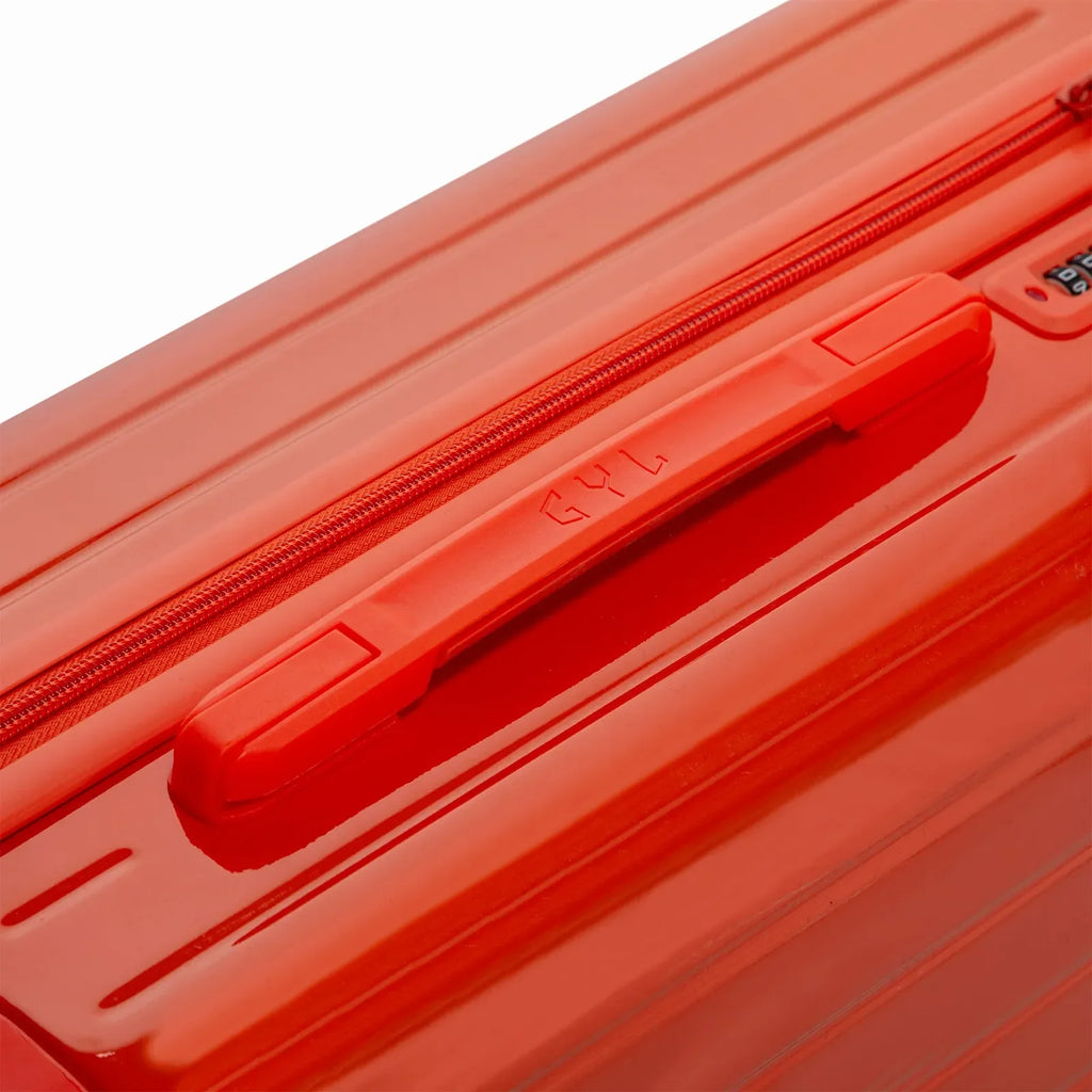 Poignée supérieure rigide de la valise GYL Intemporelle orange avec logo embossé sur le dessus. #couleur_orange foncé