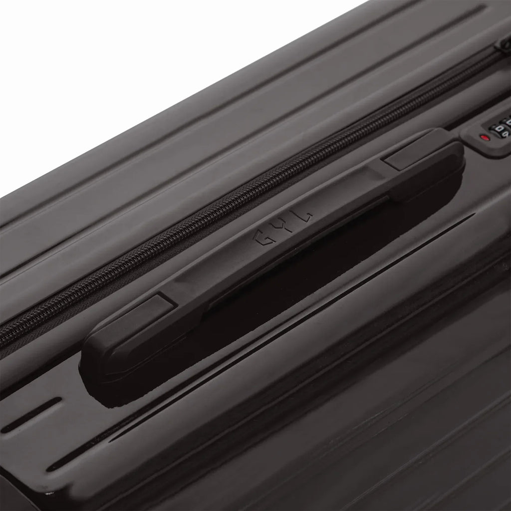 Poignée supérieure rigide de la valise GYL Intemporelle noir avec logo embossé sur le dessus. #couleur_noir