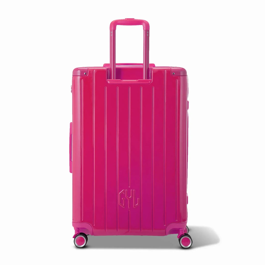 Vue arrière de la valise rigide GYL Intemporelle fuchsia avec poignées intégrées et roulettes pivotantes. #couleur_fuchsia