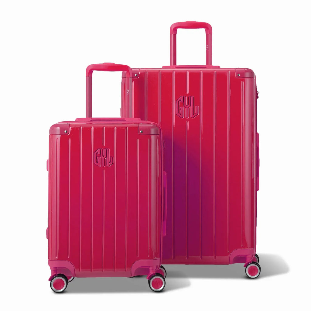Deux valises rigides GYL Intemporelle fuchsia, format cabine et soute, avec poignée trolley déployée. #couleur_fuchsia