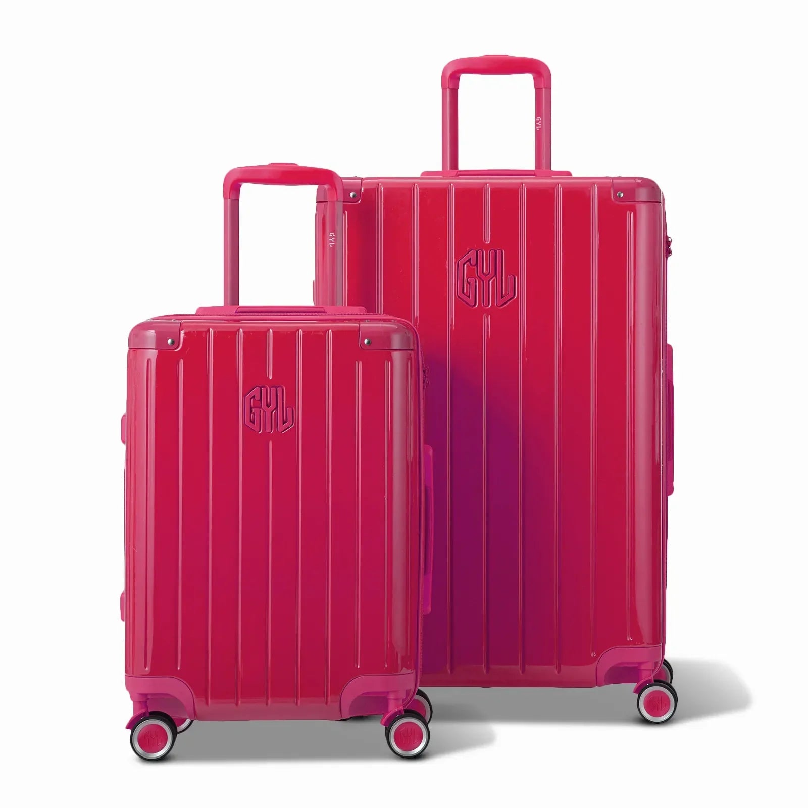Deux valises rigides GYL Intemporelle fuchsia, format cabine et soute, avec poignée trolley déployée. #couleur_fuchsia