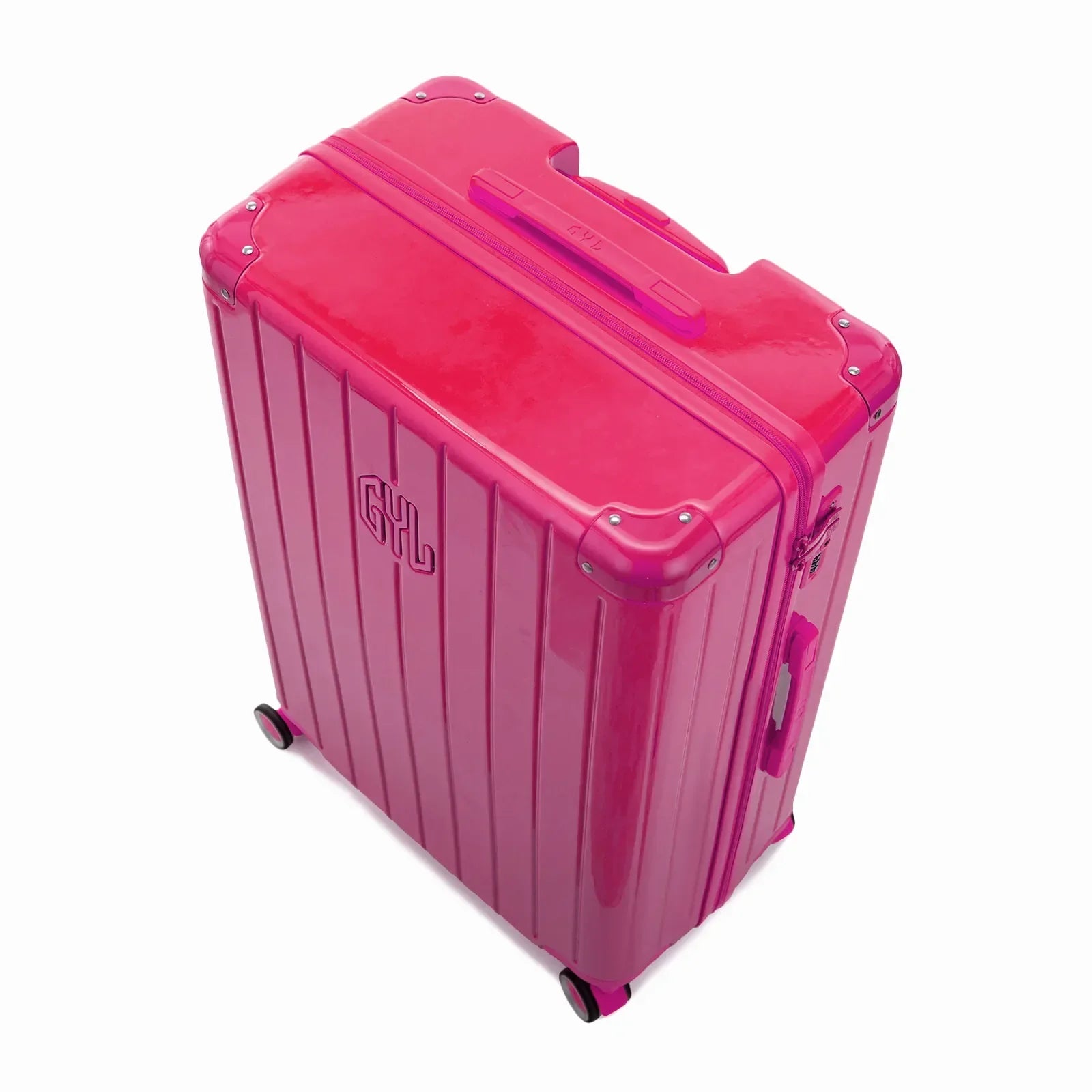 Vue en angle de la valise rigide GYL Intemporelle fuchsia avec coins renforcés et coque nervurée brillante. #couleur_fuchsia