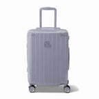 Vue avant de la valise rigide GYL Intemporelle argent, logo embossé et roulettes 360 degrés. #couleur_argent