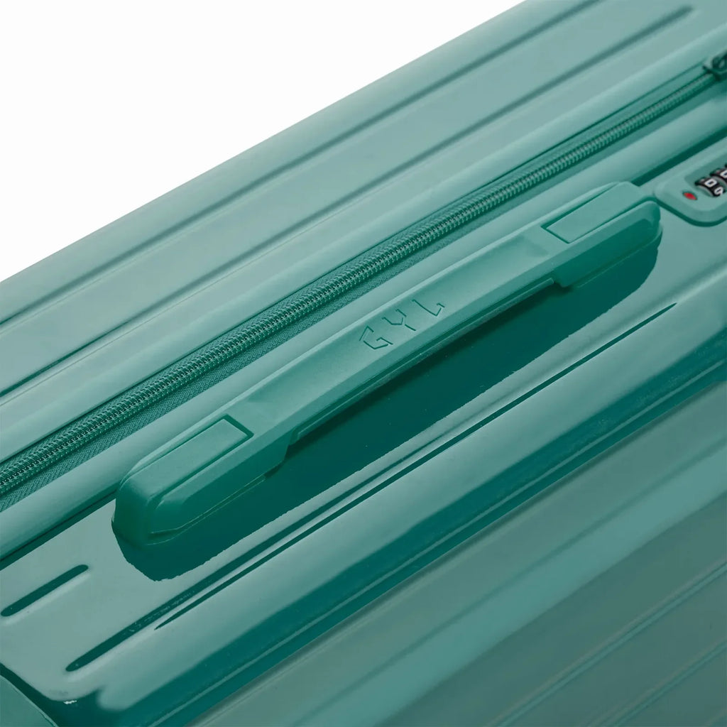 Poignée supérieure rigide de la valise GYL Intemporelle vert d'eau avec logo embossé sur le dessus. #couleur_vert