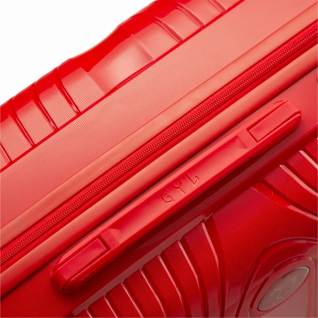 Détail de la poignée latérale et du logo GYL sur la valise Signature rouge. #couleur_rouge