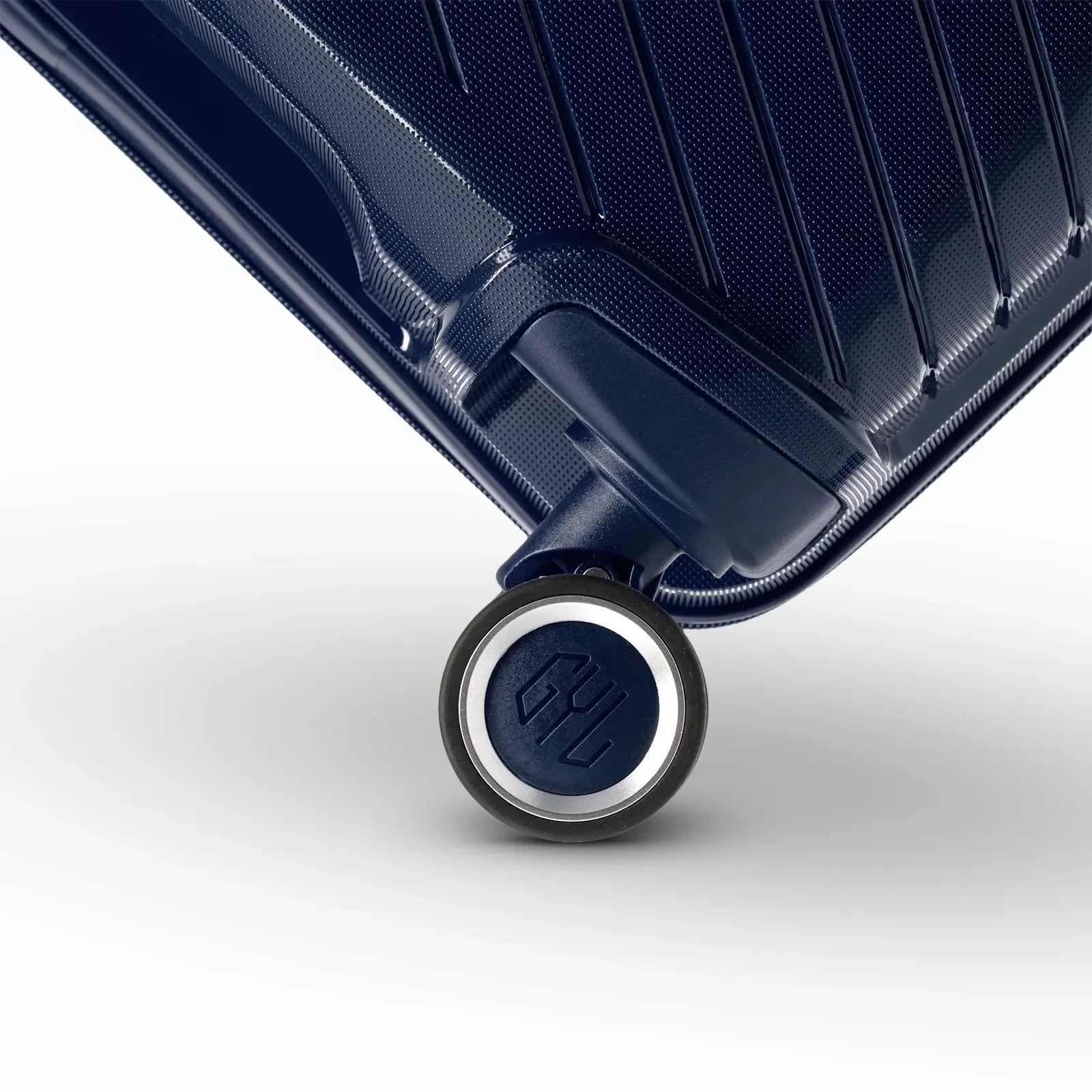 Détail de la roue avec logo GYL sur la valise Signature marine en polypropylène brillant. #couleur_marine