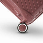 Détail de la roue avec logo GYL sur la valise Signature rose gold en polypropylène brillant. #couleur_rose gold