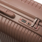 Détail de la serrure TSA intégrée et des curseurs sur la valise Signature champagne. #couleur_champagne