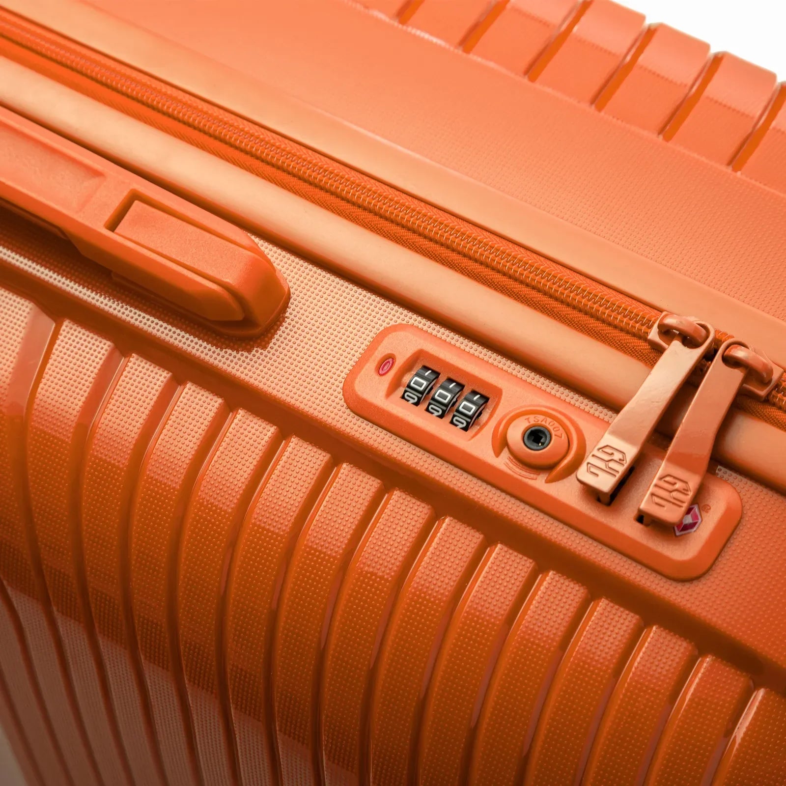Détail de la serrure TSA intégrée et des curseurs sur la valise Signature orange. #couleur_orange