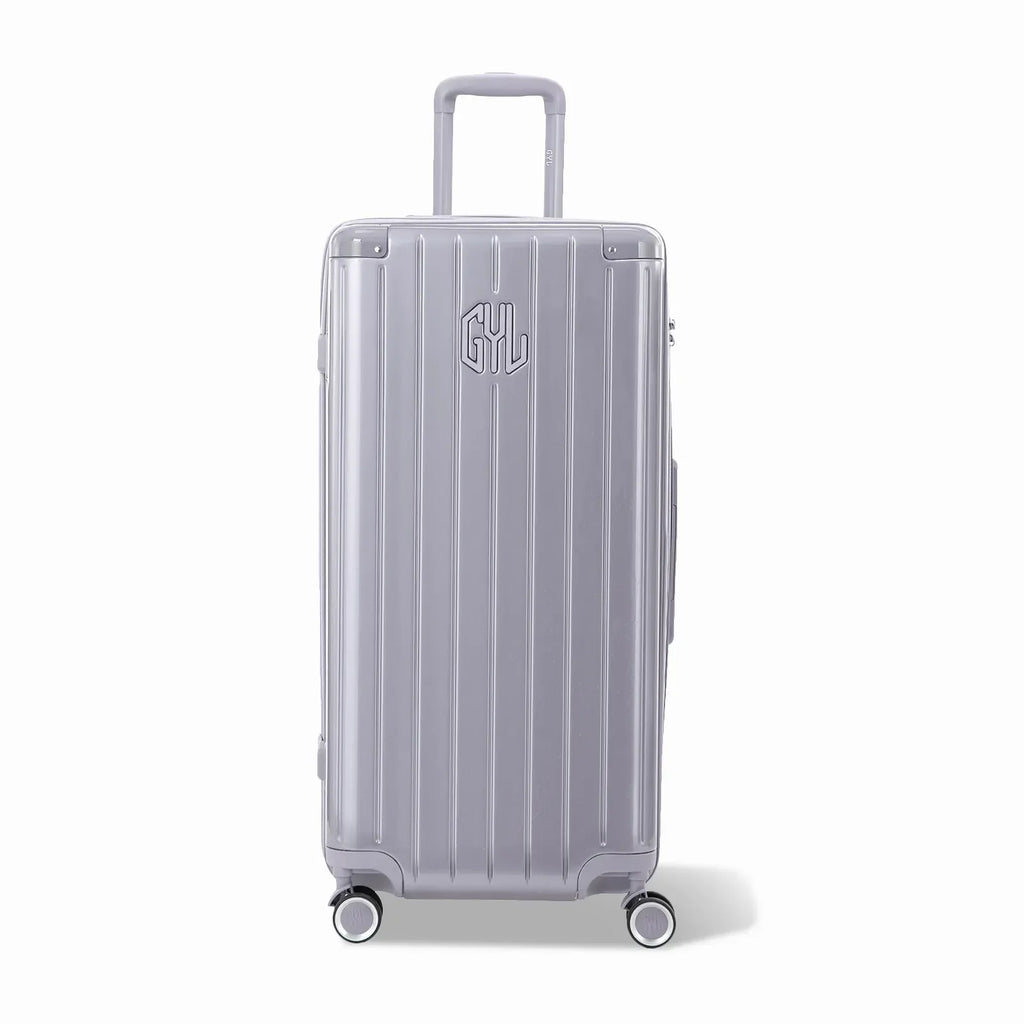 Valise trunk GYL taille XL en polycarbonate argent vue de face, avec trolley déployé et roues 360°. #couleur_argent