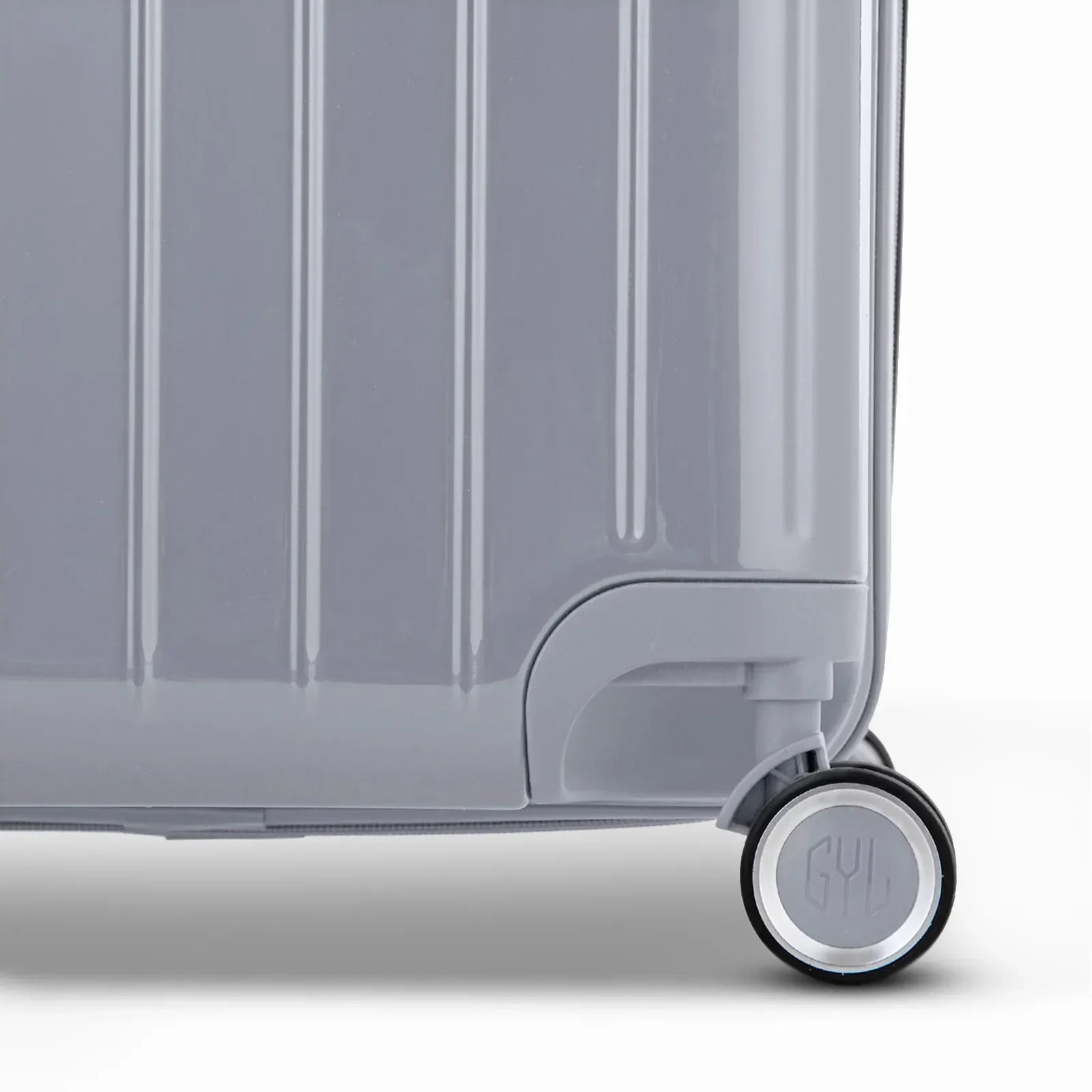 Détail de la roue et du logo GYL sur le bas de la valise trunk argent en polycarbonate brillant. #couleur_argent